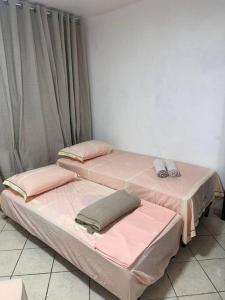 two beds sitting next to each other in a room at Excelente apartamento no centro in Macaé