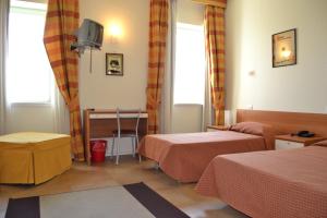 una camera d'albergo con due letti e un tavolo di Albergo Umbria a Otricoli