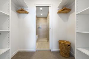 a bathroom with white walls and a walk in closet at Inviting Family-Friendly Sanctuary in Wright - Hosted by Canstay in Weston Creek +23 photos