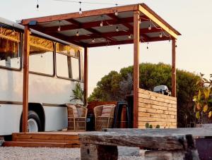 a bus with a pavilion with chairs and a table at The Bus Stop in Marion Bay +1 photo