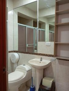 a bathroom with a sink and a toilet and a mirror at La campiña in Lima