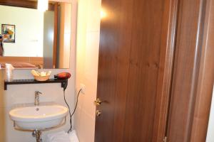 un bagno con lavandino, water e specchio di Albergo Umbria a Otricoli