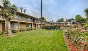 an exterior view of a building with a yard at Rose Garden Inn - San Jose Airport in San Jose