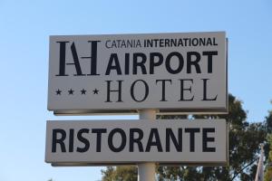 a black and white street sign on a pole at Catania International Airport Hotel in Catania
