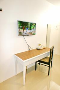 a white desk with a chair and a tv on the wall at Non Du Lay Guesthouse in Ko Lanta