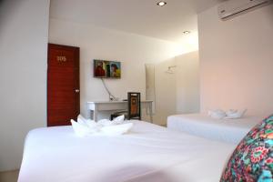 ランタ島にあるNon Du Lay Guesthouseの白い花が飾られたベッド2台が備わる客室です。