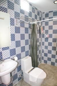 a blue and white bathroom with a toilet and a sink at Non Du Lay Guesthouse in Ko Lanta
