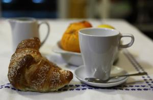 a table with a cup and a croissant and cups and croissants at Villa Anna "Davvero sulla Spiaggia" in Vasto +5 photos