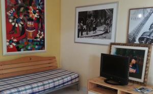 a room with a television and a bench and pictures at Villa Anna "Davvero sulla Spiaggia" in Vasto
