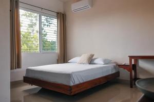 a bedroom with a bed and a large window at Apartamento 22 in Bacalar