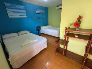 a bedroom with two beds and a table with a desk at Chill Garrobo in El Gigante