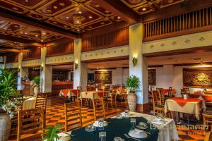 a restaurant with tables and chairs in a room at Wienglakor Hotel Lampang in Lampang