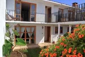 a white house with a balcony and orange flowers at Gaia Guest House in San Cristóbal de Las Casas