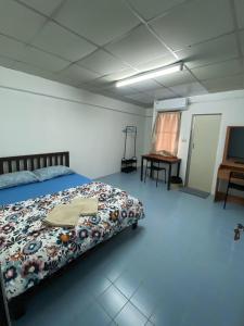 a bedroom with a bed and a table in it at รัตนากร แมนชั่น in Bang Su