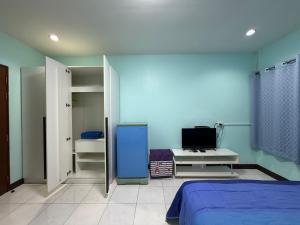 a bedroom with a bed and a blue wall at Best Rent a Room in Nai Yang Beach