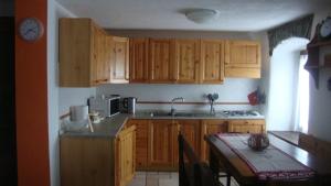 a kitchen with wooden cabinets and a sink and a table at Appartamento Vacanza Pila cir 0089 in Pila