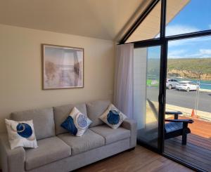 a living room with a couch and a sliding glass door at Southern Ocean Motor Inn in Port Campbell +27 photos