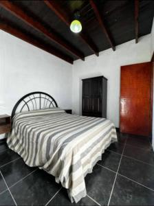 a bedroom with a large bed with a striped blanket at Casa WIWI in La Estancia