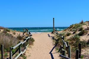 a sandy path leading to the ocean on a beach at Camping Relax Sol in Torredembarra