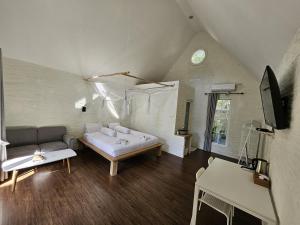 a living room with a bed and a couch at Pasir Putih resort & Cafe in Maluk