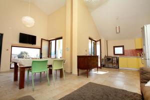 a living room with a table and chairs and a kitchen at Villa Irena in Vinišće