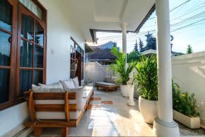 a porch with a couch and some potted plants at Private 3BR Villa Bali Work & Relax Retreat near Canggu, Bathtub in Dalung