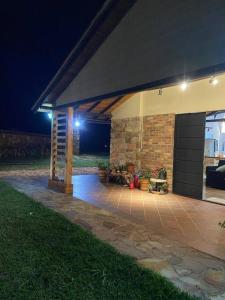 a covered patio with a brick building at night at Parcela Monte Alto Galería in Los Santos