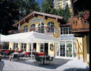 ein Restaurant mit Tischen und Stühlen vor einem Gebäude in der Unterkunft Romantikpension Villa Anna in Bad Gastein