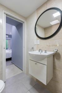 ein Badezimmer mit Waschbecken und Spiegel in der Unterkunft La Casona Apart & Suites in Ezeiza + 100 Fotos