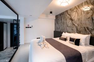 ein Schlafzimmer mit einem großen Bett mit einer Steinwand in der Unterkunft Futuristic Pool Villa with Stunning Mountain View in Chiang Mai + 76 Fotos