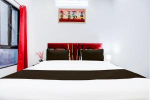 a bedroom with a large white bed with a red headboard at Hotel O Virat Inn in Lucknow +22 photos