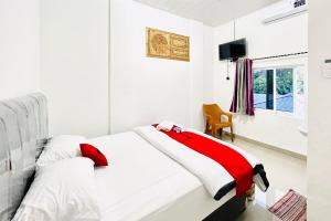 Кровать или кровати в номере RedDoorz at Orien Guesthouse Pematang Siantar