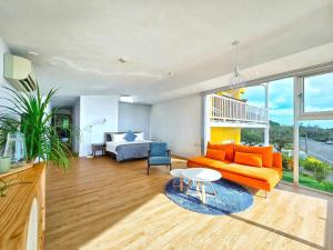 a living room with an orange couch and a table at Chuanfan600villa kenting in Eluan