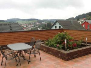 una mesa y sillas en un balcón con vistas en Landhaus Panoramablick en Schonach