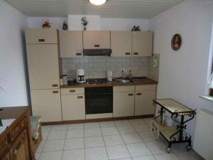 a kitchen withige cabinets and a stove top oven at Landhaus Panoramablick in Schonach