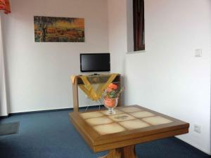 Habitación con mesa y TV en la pared. en Landhaus Panoramablick, en Schonach