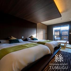 two beds in a hotel room with a window at 糸島 リゾート Tumugu in Fukuoka