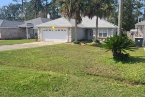 a house with a garage with a palm tree at 3BR Family Home Near NAS Pensacola in Pensacola
