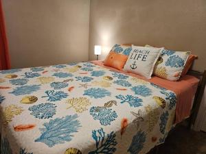 a bed with a colorful blanket and pillows on it at 3BR Family Home Near NAS Pensacola in Pensacola