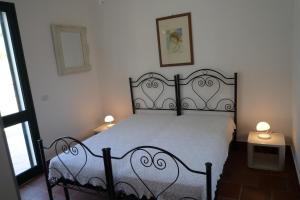 ガリポリにあるVilla FIOR DI LOTO Baia Verde Gallipoliのベッドルーム1室(黒いベッド1台、ランプ2つ付)