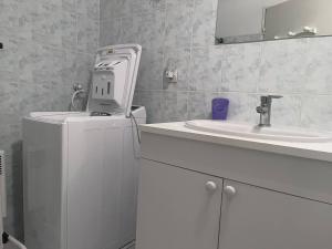a white bathroom with a sink and a white refrigerator at Charmant Appartement à Cauterets - Confort et Accueil Chaleureux - FR-1-812-101 in Cauterets