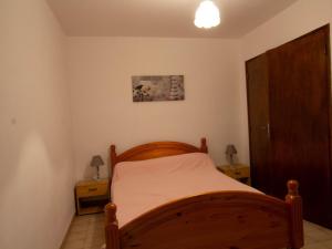 a bedroom with a wooden bed and two night stands at Gîte à la ferme avec piscine et wifi près de Bergerac - FR-1-616-396 in Naussannes