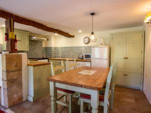 a kitchen with a wooden table and a refrigerator at Maison de charme avec jardin clos et Wifi au cœur du Périgord Noir - FR-1-616-401 in Saint-Pompont