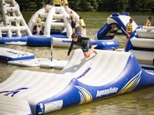 a young boy is riding on an inflatableagoguation in the water at Gîte cosy 4 pers., terrasse, proche activités nature, WiFi, parking à Cherveix-Cubas - FR-1-616-392 in Cherveix-Cubas