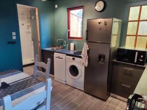 a kitchen with a refrigerator and a washing machine at Chalet rustique au cœur du Périgord Noir avec terrasse et confort inclus - FR-1-616-397 in Saint-Pompont