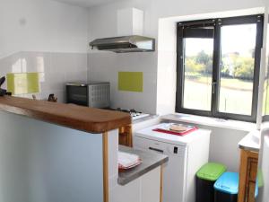 a small kitchen with a counter and a window at Gîte charmant à Groléjac avec parking, WiFi et jardin clos - FR-1-616-428 in Groléjac +3 photos