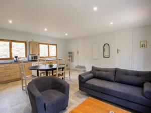 a living room with a couch and a table and a kitchen at Chalet bois intime avec Wifi, piscine partagée, à 1 km de St Pompont - FR-1-616-429 in Saint-Pompont