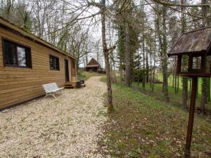 a log cabin with a bench in the woods at Chalet bois intime avec Wifi, piscine partagée, à 1 km de St Pompont - FR-1-616-429 in Saint-Pompont