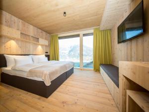 una camera da letto con un letto grande e una televisione di Das Wiesegg a Fügenberg