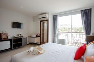 a hotel room with a bed with towels on it at The Wings Boutique Hotels Krabi Ko Lanta in Ko Lanta